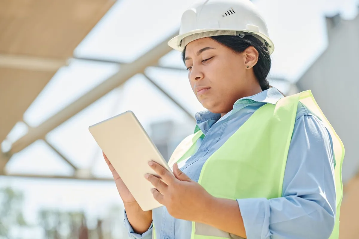 Engineer reviewing a tablet at a construction site; illustrative stock photograph, not a Silex client